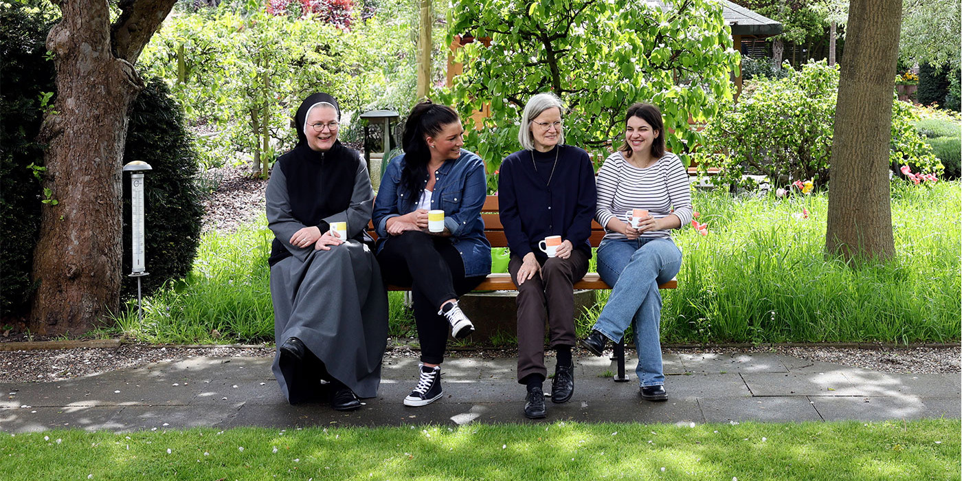 Eine Gruppenaufnahme von Nonnen und Personal auf einer Bank